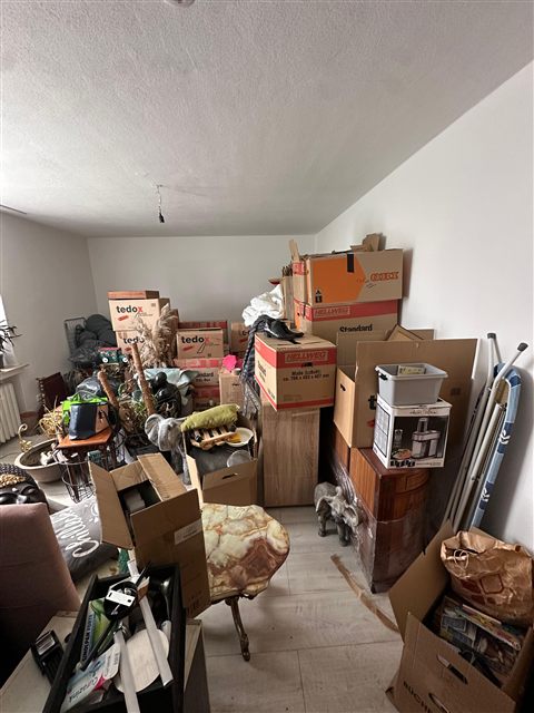 Möbel und Kartons in einem zu räumenden Zimmer